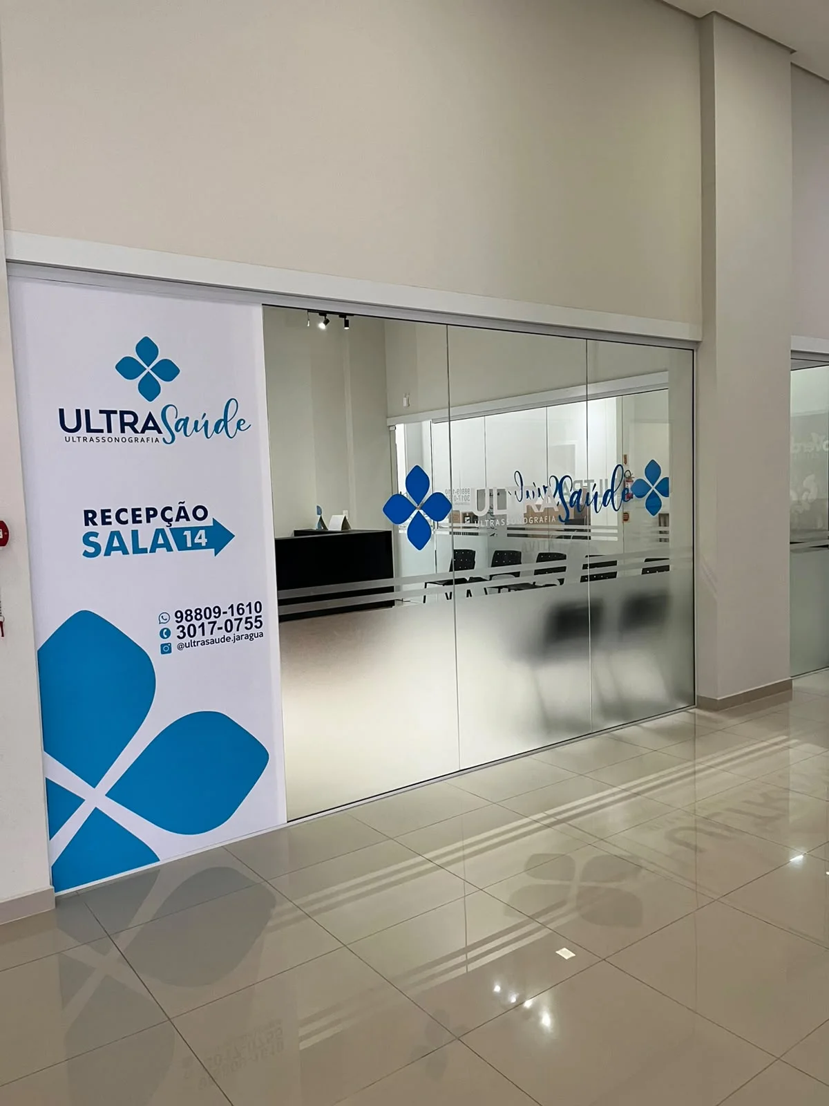 Entrada da Ultra Saúde com placa indicando a recepção na sala 14